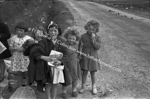 CHILDREN WAITING IN GROUP AT SIDE OF ROAD